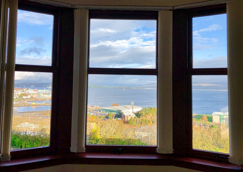 A window in three parts looks out over The Clyde and Greenock, Scotland.